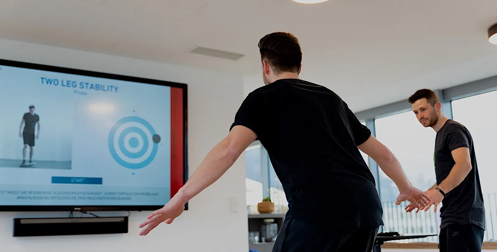 Sportwissenschafter begleitet einen Stabilitätstest vor dem Bildschirm